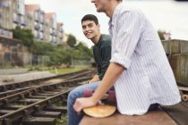 Two young men sitting by train track, Bristol, UK — Stock Photo