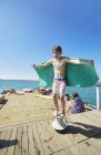 Junge balanciert auf Liegeplatz auf Hausboot-Sonnendeck, Kraalbaai, Südafrika — Stockfoto