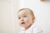 Portrait of baby girl at home, curious expression — Stock Photo