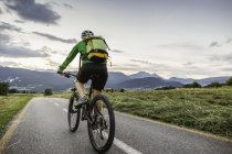 Woman cycling on road, Fondo, Trentino, Itália — Fotografia de Stock