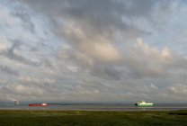 Naves navegando hacia y desde el puerto de Amberes. Central nuclear en segundo plano, Rilland, Zelanda, Países Bajos - foto de stock