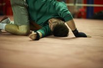 Young man exercising in boxing gym, stretching — Stock Photo