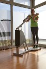 Mature woman doing weightlifting exercise on gym exercise machine — Stock Photo