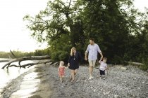 Взрослые родители прогуливаются с мальчиком и девочкой на озере Онтарио, Ошава, Канада — стоковое фото