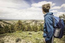 Чоловічий підліткової мандрівного дивлячись в ландшафт, коді, Вайомінг, США — стокове фото