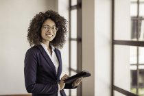 Портрет молодой предпринимательницы с помощью цифрового планшета в офисе — стоковое фото
