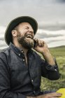 Чоловічий мандрівного сміючись в той час як за допомогою смартфона, коді, Вайомінг, США — стокове фото