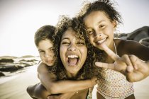 Щаслива мати і діти показують знак миру на пляжі — стокове фото