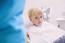 Mädchen im Zahnarztstuhl blickt in die Kamera — Stockfoto