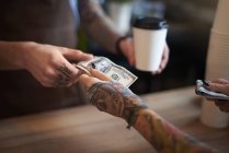 Customer paying for her coffee with cash — Stock Photo
