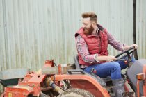 Mann fährt Traktor auf Bauernhof — Stockfoto