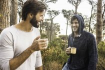 Two men drinking coffee and chatting in forest, Deer Park, Cape Town, South Africa — Stock Photo