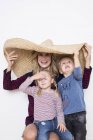 Mulher vestindo sombrero, protegendo a si mesma e dois filhos — Fotografia de Stock