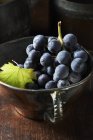 Vista ad alto angolo di grappolo di uva nera in tazza da tè vintage — Foto stock