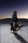 Uomo maturo cane da passeggio nella neve di notte — Foto stock