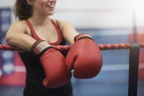 Cropped shot of young female boxer leaning on boxing ring ropes — Stock Photo