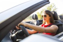 Young woman driving on rural road in convertible, Majorca, Spain — Stock Photo