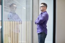 Male designer looking out from window in design studio — Stock Photo