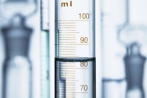 Мениск воды в градуированном цилиндре, объем жидкости измеряется шкалой считывания на дне мениска — стоковое фото