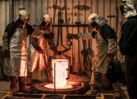 Ouvriers de fonderie treuil blanc chaud creuset dans la fonderie de bronze — Photo de stock
