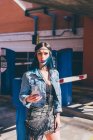 Молода жінка з зануреним пофарбованим блакитним волоссям використовує смартфон у міському житловому комплексі — стокове фото