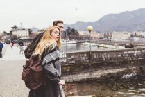 Coppia giovane che guarda oltre le spalle al lago, Lago di Como, Italia — Foto stock