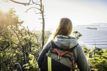 Female hiker looking out from coastal forest, Pacific Rim National Park, Vancouver Island, British Columbia, Canada — Stock Photo
