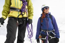 Alpinistas na paisagem coberta de neve olhando para longe — Fotografia de Stock