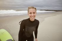 Retrato de una joven surfista en Rockaway Beach, Nueva York, EE.UU. - foto de stock