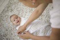 Über-die-Schulter-Ansicht der Mutter windelnder Baby-Junge mit Decke — Stockfoto
