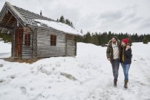 Couple hiking from log cabin in winter, Elmau, Bavaria, Germany — Stock Photo