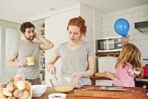 Mitte erwachsene Frau schwenkt Eier an der Küchentheke zum Familienfrühstück — Stockfoto