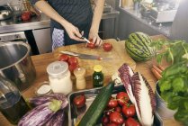 Immagine ritagliata dello chef che taglia i pomodori alla cucina commerciale — Foto stock