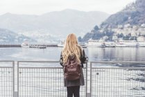 Задній вид молода жінка з видом на озеро Комо, Італія — стокове фото