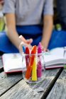 Jar of crayons close up with girl in background — Stock Photo