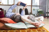 Paar nutzt digitales Tablet auf dem Boden — Stockfoto