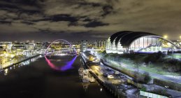 Tyne Bridge, Millennium Bridge, Sage building y River Tyne, por la noche, Newcastle, Reino Unido - foto de stock