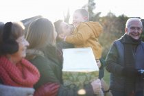 Family at birthday celebration in garden together during cold weather — Stock Photo