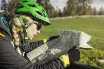 Mulher usando capacete de ciclismo leitura mapa, Jenesien, Tirol do Sul, Itália — Fotografia de Stock