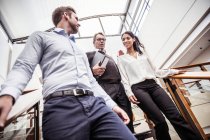 Geschäftsleute und Geschäftsfrau diskutieren über Umzug in Bürotreppe — Stockfoto