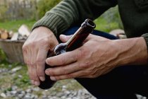 Mains masculines tenant bouteille de bière en verre — Photo de stock