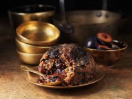 Sugar plum pudding with spoon on plate — Stock Photo