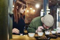 Coffee-Shop-Team riecht Schalen mit Kaffee und Kaffeebohnen bei der Verkostung — Stockfoto
