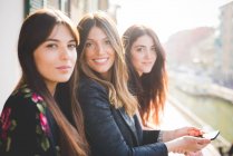 Porträt von drei jungen Freundinnen auf dem Balkon am Wasser — Stockfoto