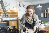 Female printer inserting paper to print machine in workshop — Stock Photo