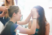 Four teenage girls doing each others hair and make up in bedroom — Stock Photo
