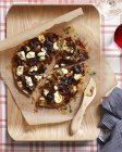 Пицца с карамелизированным луком на доске — стоковое фото