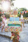 Menina com pilha de presentes de aniversário na festa com amigos — Fotografia de Stock