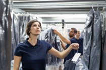 I lavoratori dei magazzini che fanno scorta di abbigliamento prendono nel magazzino di distribuzione — Foto stock
