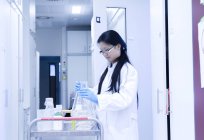 Женщина-ученый готовит экспериментальное оборудование для тележки в лаборатории — стоковое фото